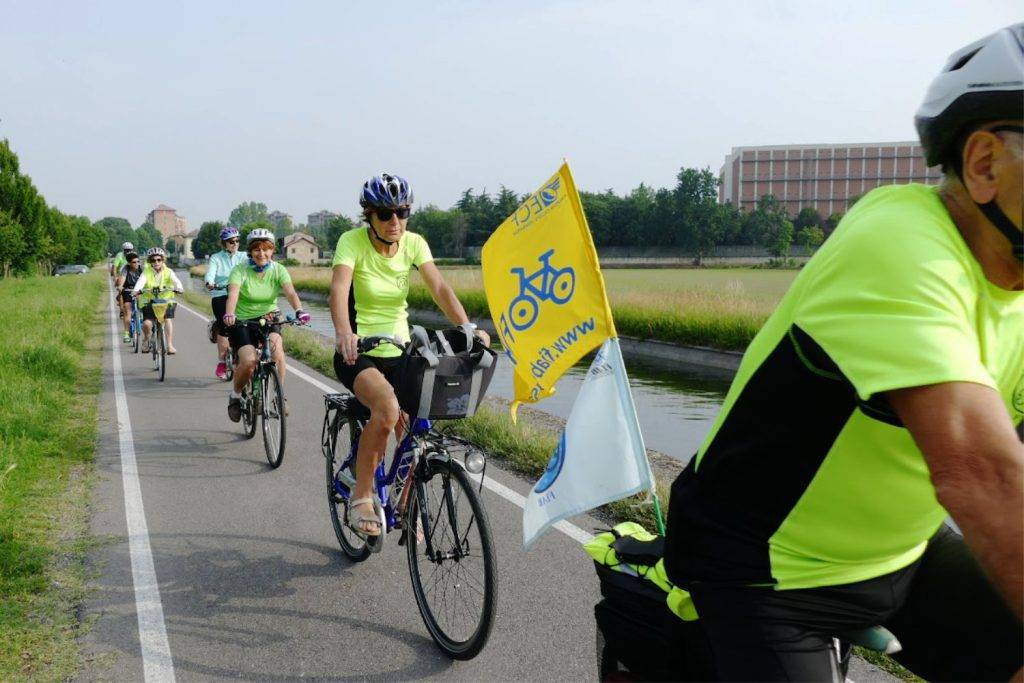 persone pedalano sull'alzaia del naviglio
